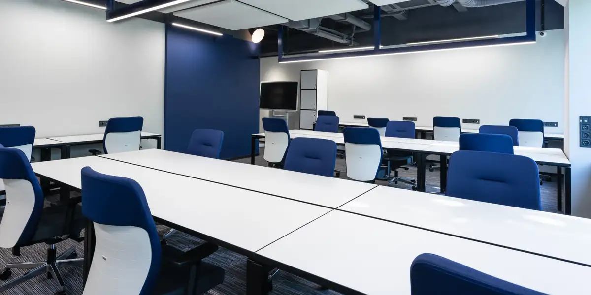 Rows of blue and white task chairs at white desks in a modern office